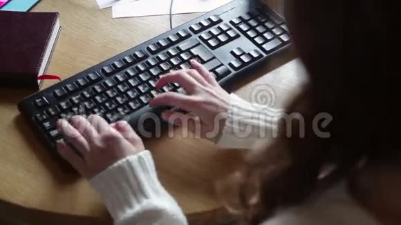穿着白色毛衣的布鲁内特在电脑上工作视频的预览图