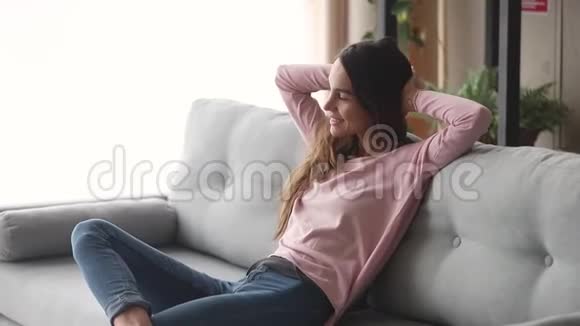 快乐懒惰的年轻女子在家里坐在沙发上放松视频的预览图