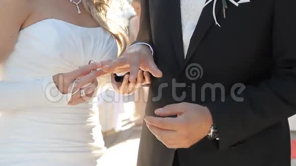 新娘把结婚戒指戴在新郎的手指上视频的预览图