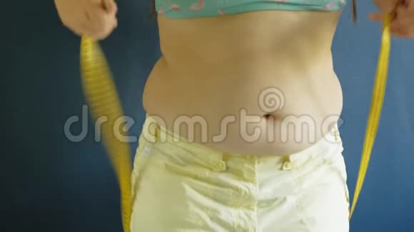 一个女人的胖肚子贴在蓝色的背景上有害食物肥胖视频的预览图