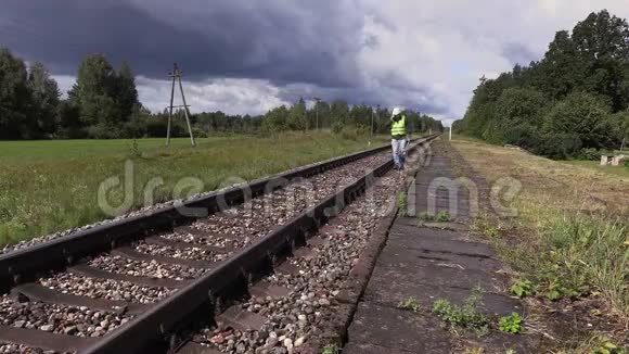 铁路工人带可调节扳手在铁路附近行走视频的预览图