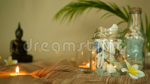 玻璃瓶中装满贝壳珊瑚蜡烛灯的海洋物品梅花坐佛装饰视频的预览图