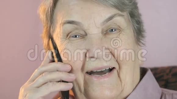 祖母在手机上微笑地交谈视频的预览图