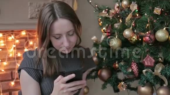 在圣诞节一个女人在家里用手机视频的预览图