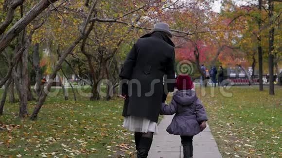 一个年轻的女人和她的女儿在公园里走来走去在小巷里玩耍和奔跑视频的预览图