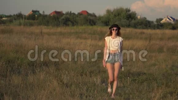 年轻的美女模特走在草地上享受大自然视频的预览图