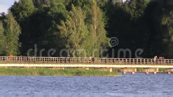 人们走在湖边的长长的木桥上视频的预览图