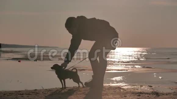 一个在夕阳下大海里带着狗的女孩视频的预览图