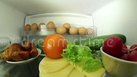 在冰箱里找食物的人肉或蔬菜之间的选择视频的预览图