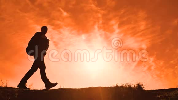 剪影阳光游客徒步旅行者带着背包从山顶的生活方式欣赏日落美景Hike视频的预览图