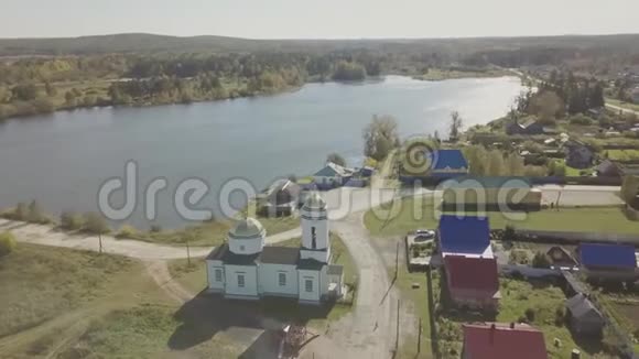 鸟瞰靠近池塘的欧洲村庄美丽的鸟瞰彩色湖和村庄与教堂顶部视图视频的预览图