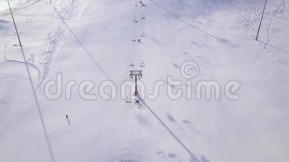 人们在冬季滑雪场的雪坡上滑雪和滑雪板滑雪电梯上雪山无人机观景冬季视频的预览图