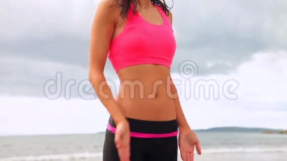 平静的黑发女人在海滩上练习瑜伽视频的预览图