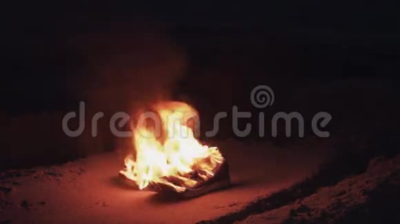 在海岸的沙滩上燃烧靴子强烈明亮的火焰夏日的黑夜视频的预览图