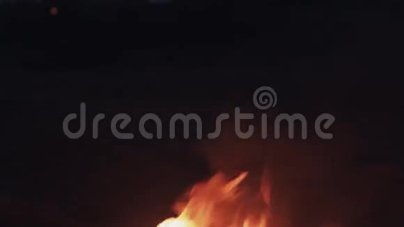 在海岸的沙滩上燃烧靴子强烈明亮的火焰夏日的黑夜视频的预览图