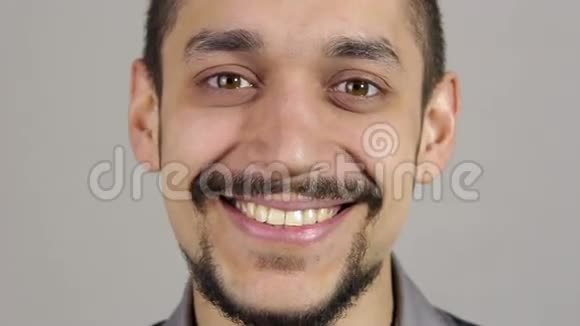 一个留胡子的年轻人的肖像笑着看着镜头视频的预览图