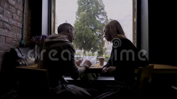一个女孩和一个男人在咖啡馆里发现了一些有趣的东西视频的预览图