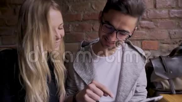 一个女孩和一个男人在咖啡馆里发现了一些有趣的东西视频的预览图