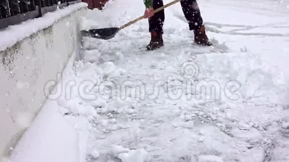 带着雪铲的人在冬天打扫人行道视频的预览图