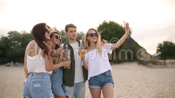 一群朋友在日落时分在海滩上玩着享受饮料和放松的乐趣男女青年视频的预览图