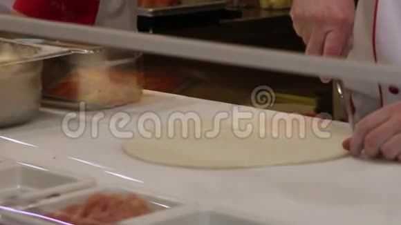 厨师用刀子切皮萨面团视频的预览图