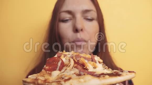 匹萨快乐的女孩吃一片披萨的概念饥饿的女人吃一片生活方式的披萨慢动作视频的预览图