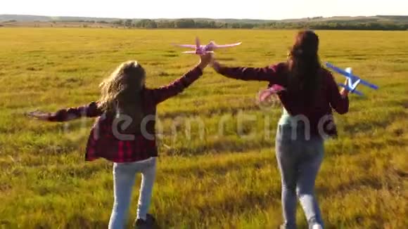 孩子们在飞机上玩耍的剪影飞行的梦想快乐的童年概念两个女孩玩玩具飞机视频的预览图