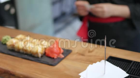 特写服务员把寿司放在餐厅的桌子上视频的预览图