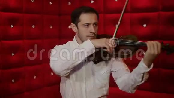 小提琴手在红色背景下演奏视频的预览图