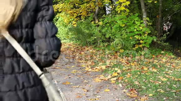 迷人的女人走在秋天公园视频的预览图