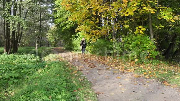 迷人的女人走在秋天公园视频的预览图