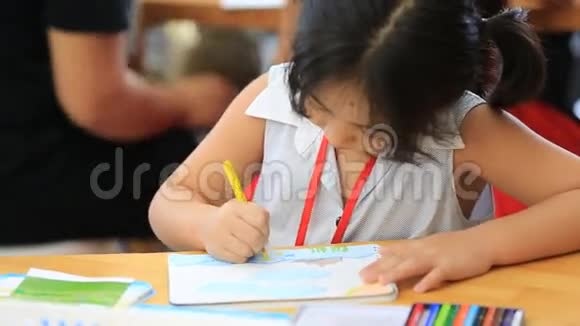 小亚洲女孩在桌子上画一幅画视频的预览图