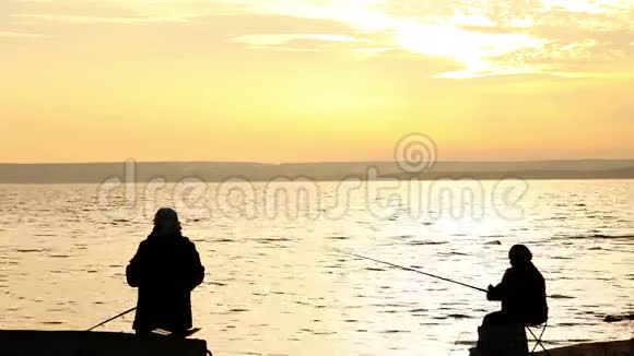 渔民在平静的日落海边视频的预览图