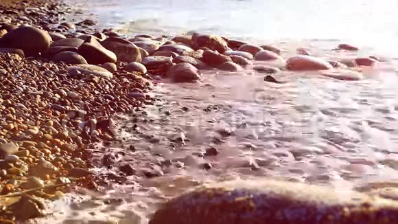 卵石滩和波浪飞溅日落时间视频的预览图