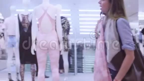年轻女子在服装店挑选服装视频的预览图