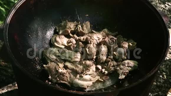 做皮拉夫菜在室外大锅里用切碎的羊肉烤蔬菜炖菜野营概念视频的预览图