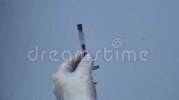 医生的手把针放在注射器上视频的预览图