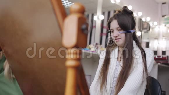 专业的发型师为一个可爱的欧洲女孩在美容院做发型视频的预览图