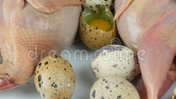 白色鹌鹑蛋旁边的塑料棕色托盘中鹌鹑的新鲜肉视频的预览图