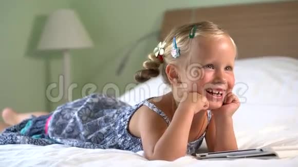 小可爱的女孩在平板电脑上玩游戏视频的预览图