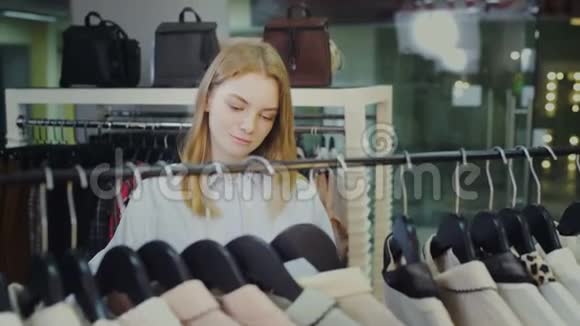 年轻的美女在服装店挑选服装视频的预览图