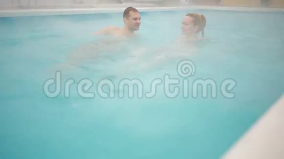 温泉地热温泉恋爱中的浪漫夫妇在热池里放松视频的预览图