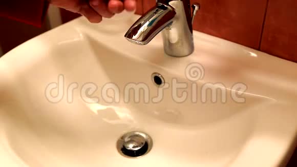 男人在浴室的水槽上洗手视频的预览图