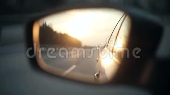 日落时汽车后视镜中的路景视频的预览图