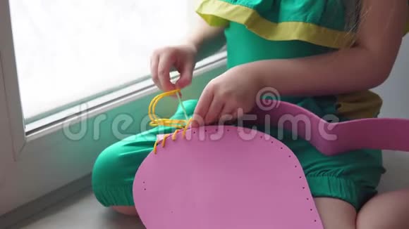 可爱的小女孩缝一个粉红色的手提包视频的预览图