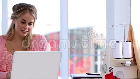 时装设计师在她的笔记本电脑上工作视频的预览图