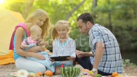 一家人坐在野餐的画像视频的预览图