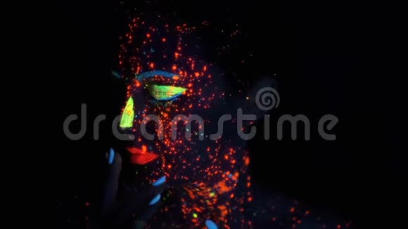 霓虹灯中女孩的肖像一个美丽的女孩的脸被涂上了发光的颜色视频的预览图