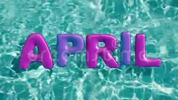 单词APIL形状的充气游泳圈漂浮在清爽的蓝色游泳池里视频的预览图
