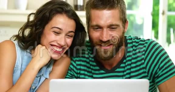 一对夫妇在笔记本电脑前笑着视频的预览图